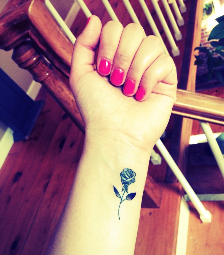 Small black-and-grey rose tattoo on the inner wrist