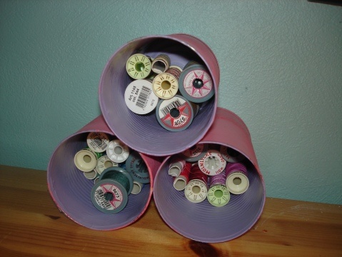 Pink tin cans storing thread spools