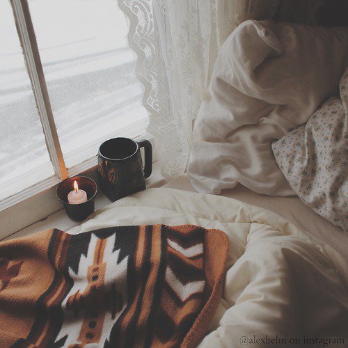 Mug and candle on snowy windowsill