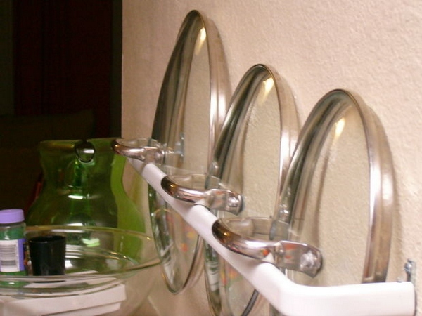 Use a small curtain rod to store lids for easy access.