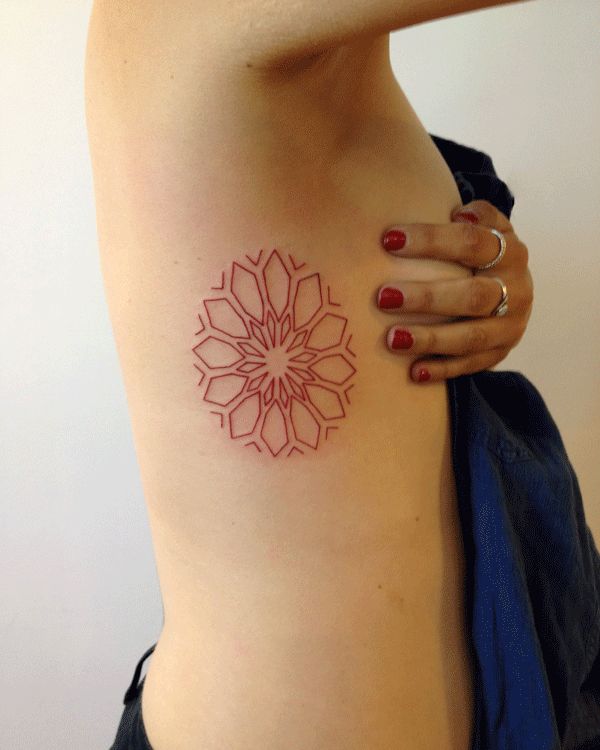 Red geometric mandala sun tattoo on ribcage