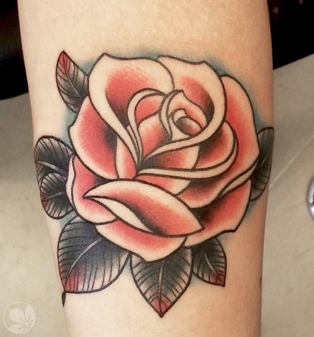 Neo-traditional coral rose with teal halo on the arm
