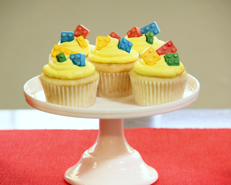 Yellow-frosted cupcakes topped with candy LEGO bricks