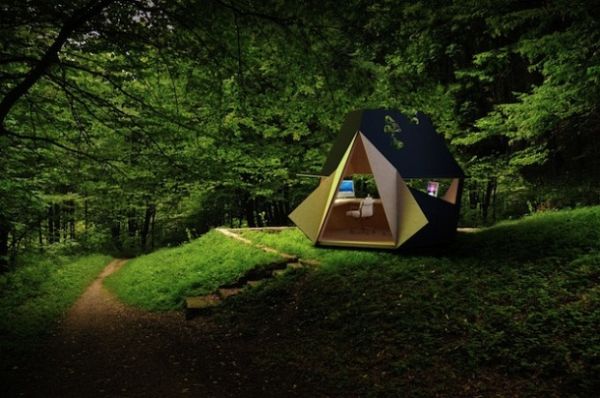 Dark origami office pod open to a forest clearing