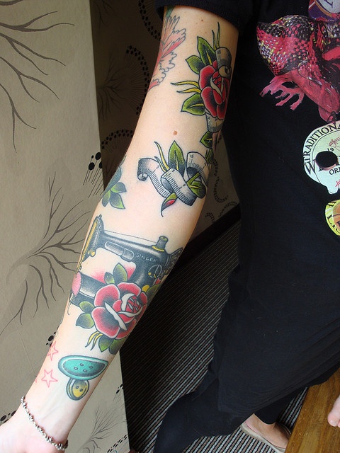 American traditional forearm tattoo featuring a Singer sewing machine and roses