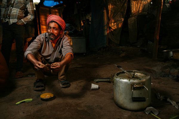 awesome-india-photos10 Man in orange turban eating with a pressure cooker nearby