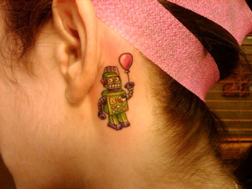 green robot with balloon tattoo behind the ear