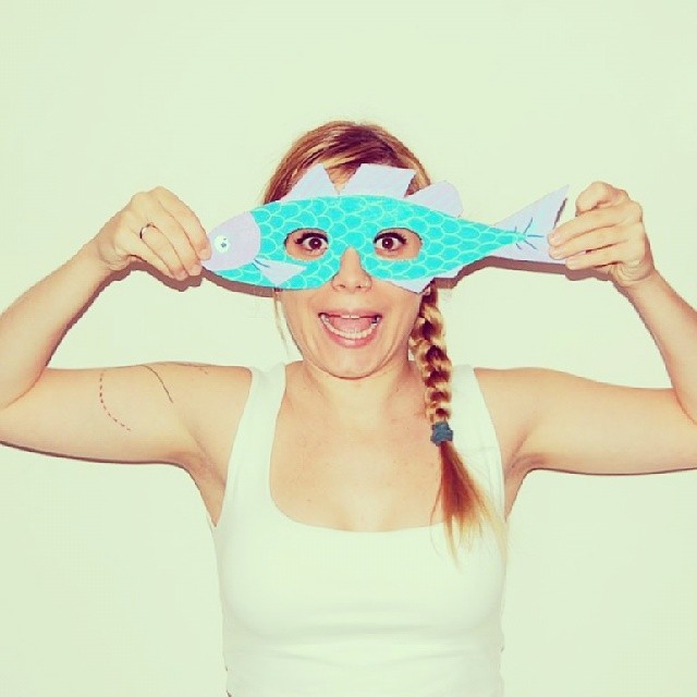 Teal and purple fish cardboard mask held to the eyes