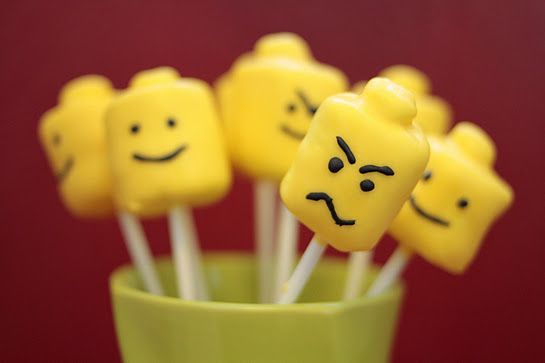 Yellow LEGO head cake pops with different facial expressions