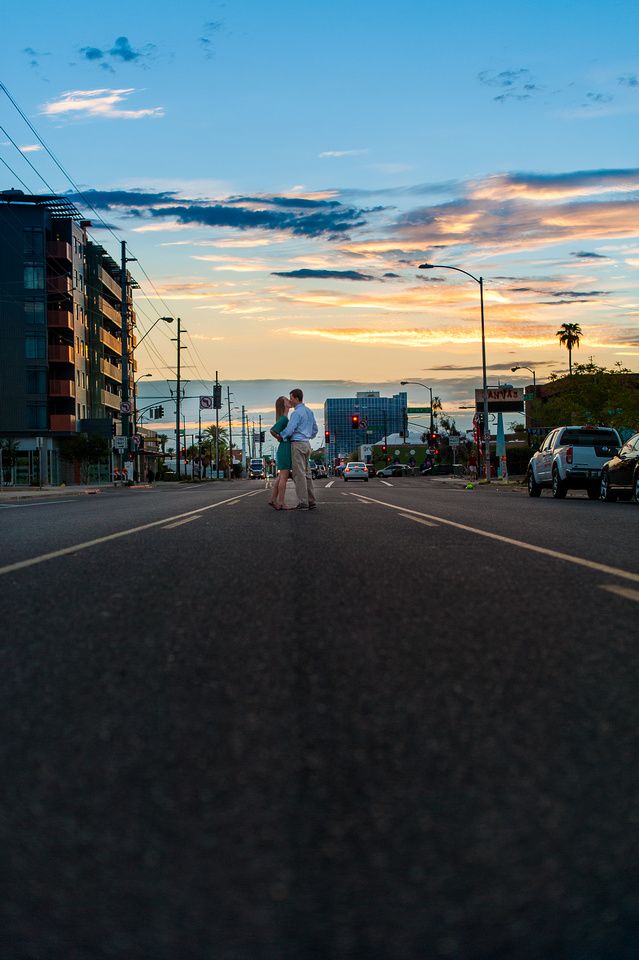 Couple kissing in the middle of a city street at sunset