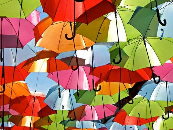 Pedestrian view under floating colourful umbrellas
