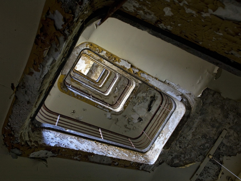Nils Eisfeld peeling paint stairwell looking up
