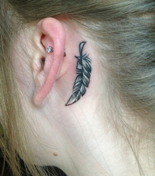 fine-line feather tattoo behind the ear