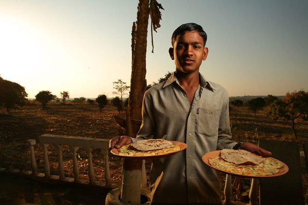 awesome-india-photos06 Young man holding two plates of food at sunset