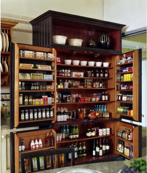 Organized kitchen pantry using bins and labeled sections