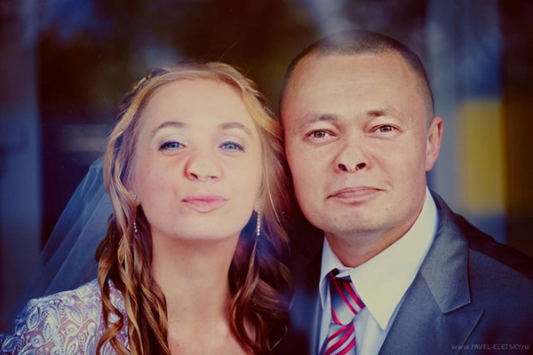 Bride and groom pressing their faces flat against glass
