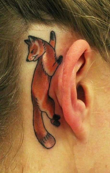 orange fox climbing behind the ear tattoo