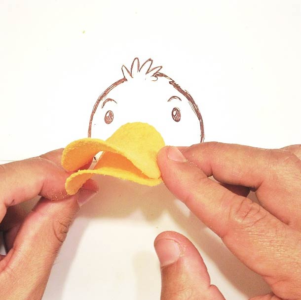 Duck face drawn with potato chips as a bill