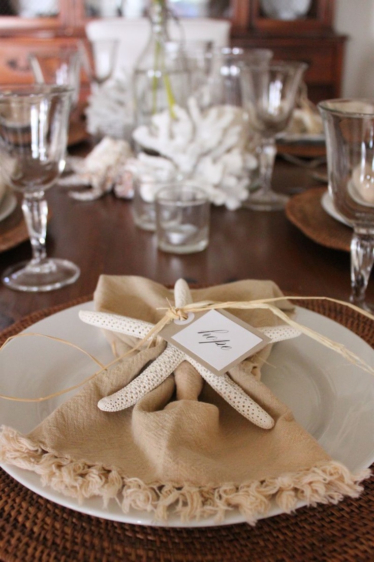 Tall coastal place setting with layered china and shells