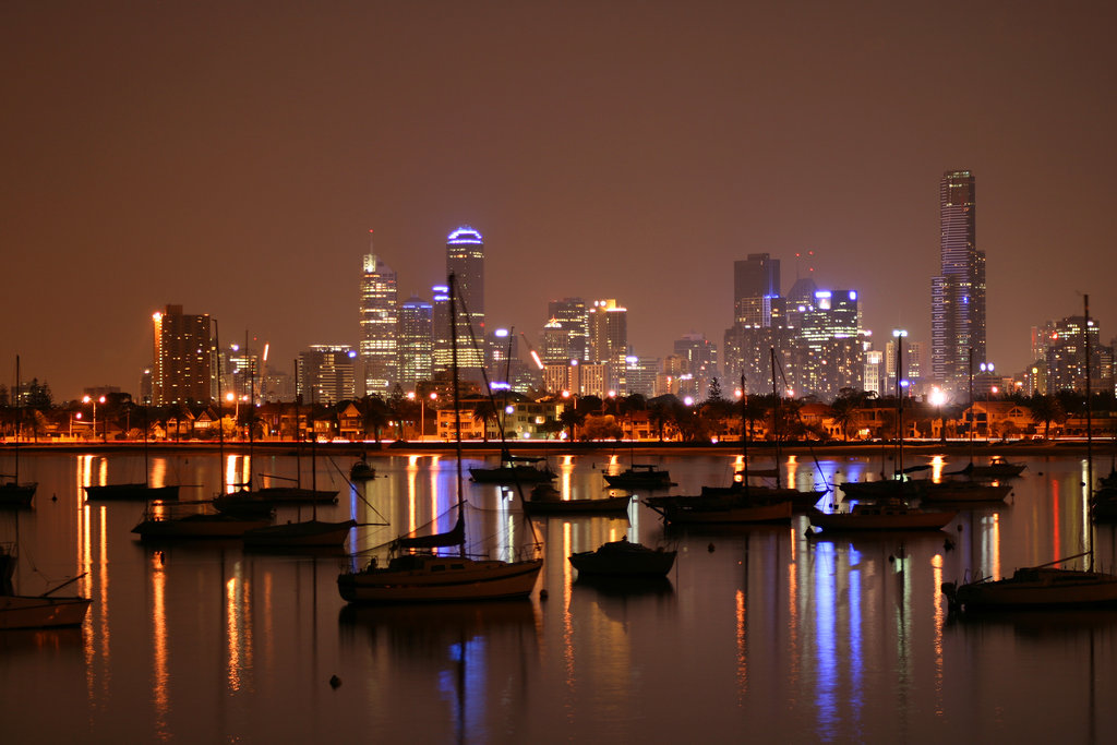 Coastal city lights at night along a curved shoreline