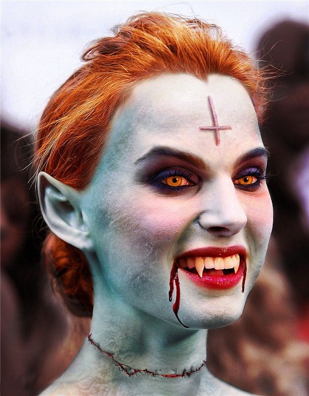 Pale green vampire with pointed ears and orange contacts