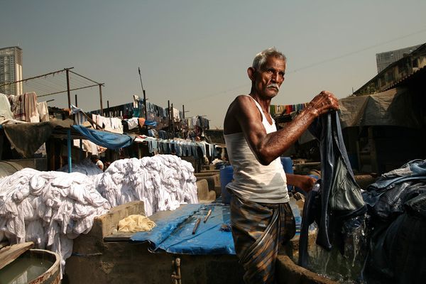 awesome-india-photos09 Washerman lifting wet cloth at an outdoor laundry