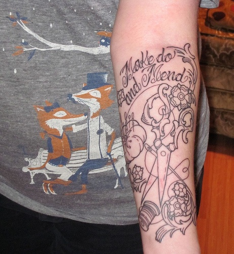 Black linework tattoo reading Make do and Mend with scissors and sewing tools