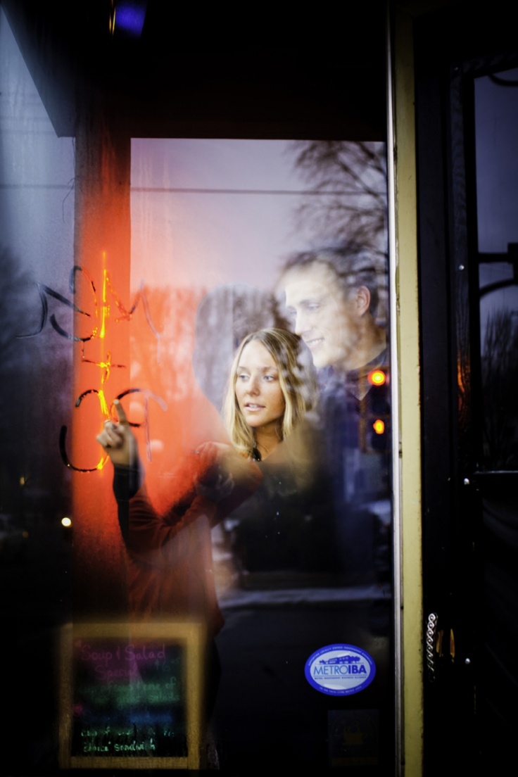 Couple seen through a café window with winter reflections