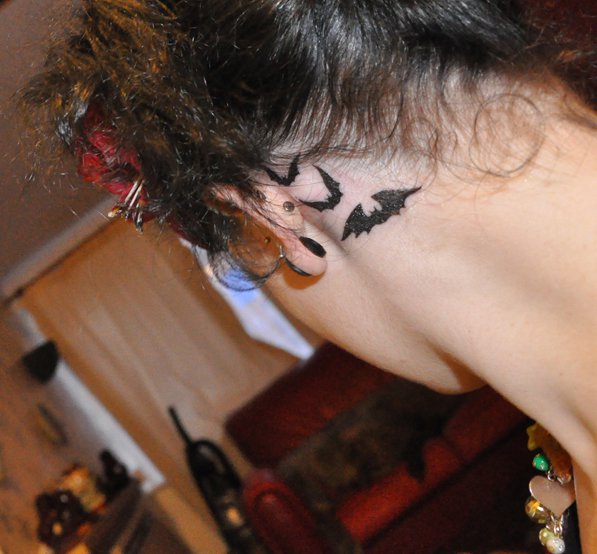 three black bat silhouettes behind the ear
