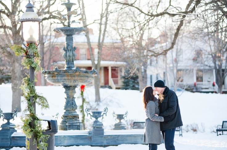 Playful winter engagement pose in holiday setting
