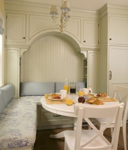 Arched cabinetry breakfast alcove with blue cushions and chandelier