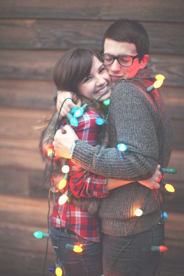 Couple wrapped together in glowing Christmas lights