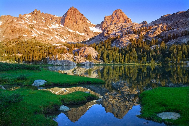 Alpine lake reflecting sunlit mountain peaks