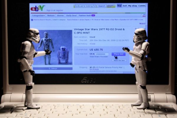 Stormtroopers on a laptop keyboard bidding on vintage R2-D2 and C-3PO