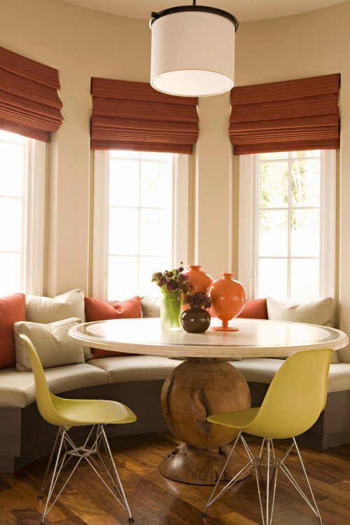 Curved bay banquette with terracotta shades and chartreuse chairs