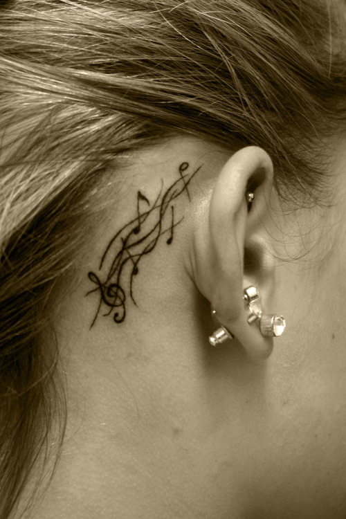 treble clef and musical staff tattoo behind ear