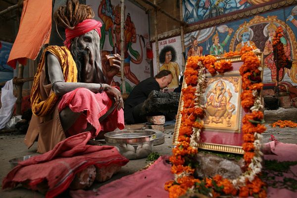 awesome-india-photos03 Devotee near a marigold-draped Ganesha shrine