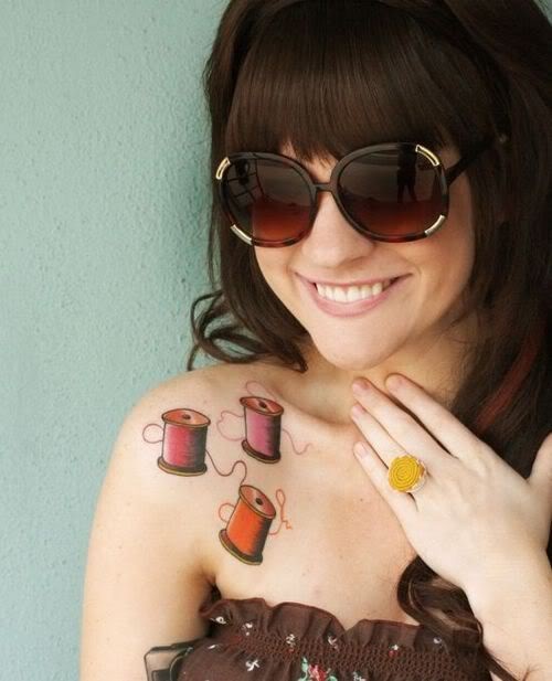 Shoulder tattoo of three colorful thread spools