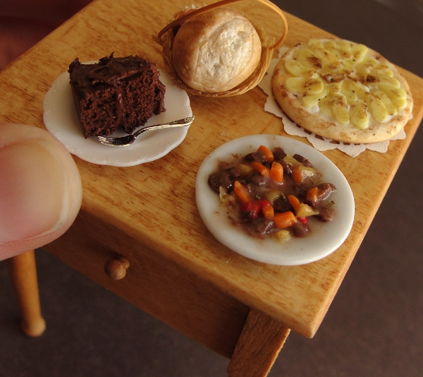 delicious-mini-foods05 Tiny wooden table set with cake, bread roll, tart, and stew