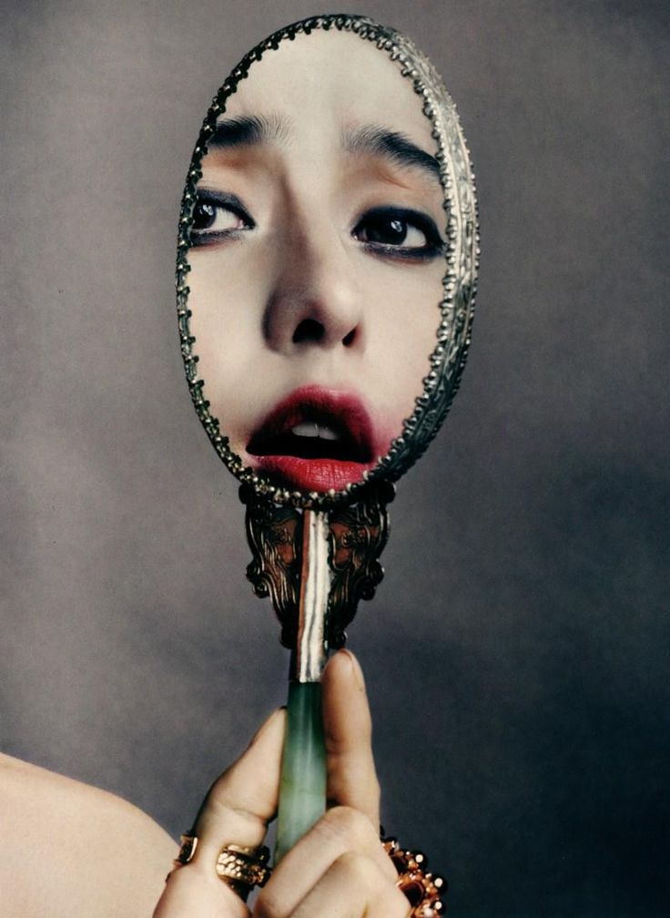 Woman and mirror in a layered reflective composition
