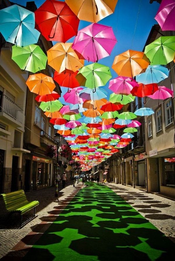 Looking along a street beneath hanging umbrellas in Portugal